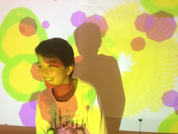 kid with generative art projected