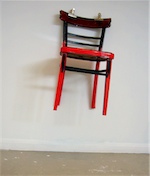 Une chaise rouge et noire accrochée à un mur